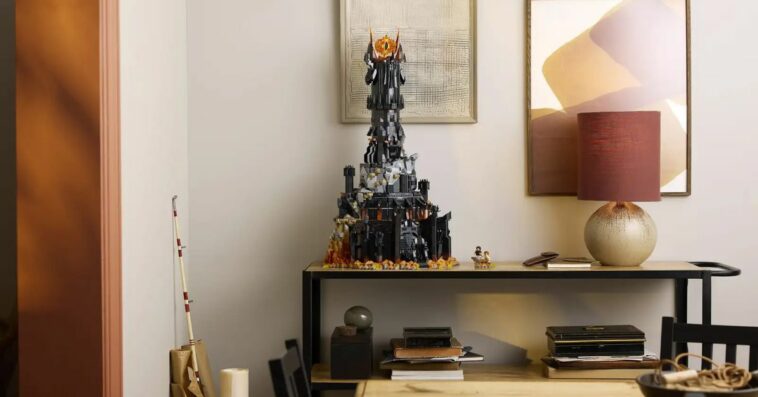 A wide-angle shot of Lego’s Barad-dûr set sitting on a table beside a lamp.