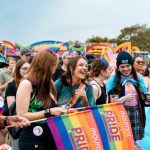 Attendees of Jersey Pride with their rainbow flags and outfits