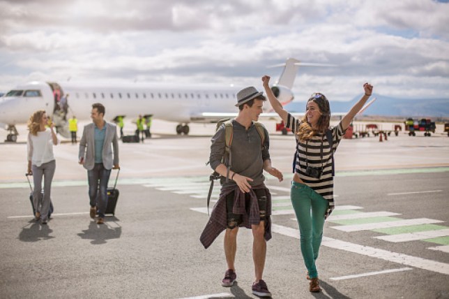 People walking across tarmac at an airport