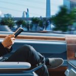 passenger reading a book in an autonomous self-driving car