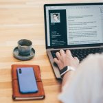 Young business woman searching for job online. Woman writing resume on laptop.