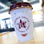 A disposable coffee cup with a plastic lid is pictured inside a branch of Pret A Manger in London