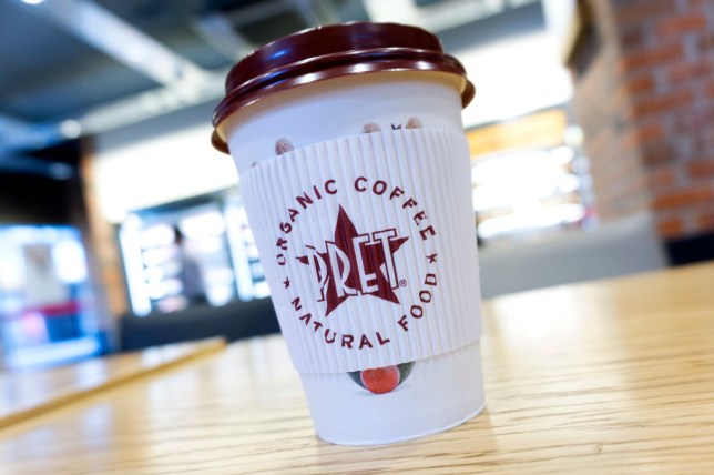 A disposable coffee cup with a plastic lid is pictured inside a branch of Pret A Manger in London