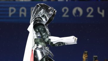 A woman carrying the Olympic flag is seen at the Trocadero during the Opening Ceremony of the Olympic Games Paris 2024