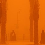 Women walk amidst a severe dust storm in Kuwait City on May 23, 2022.