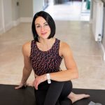 Niki Woods on a yoga mat, in activewear, smiling to camera