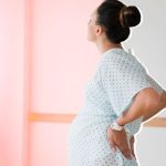 A pregnant woman stands in a hospital room after having IVF to become a single mother