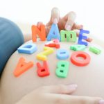 Pregnant belly with letter blocks spelling out 'name'