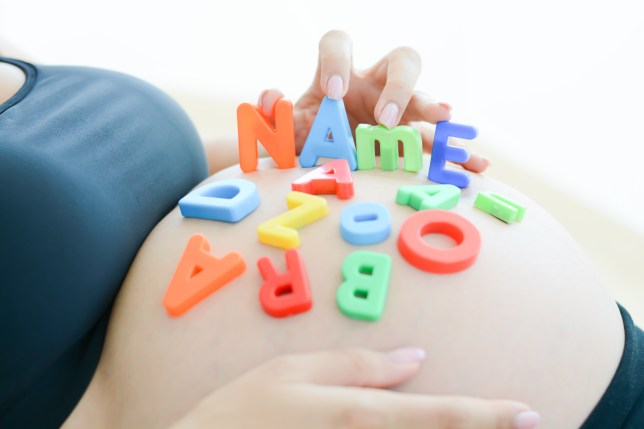 Pregnant belly with letter blocks spelling out 'name'