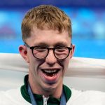 Gold medalist Daniel Wiffen, of Ireland, poses for a photo with his national flag on the podium following the men's 800-meter freestyle final at the 2024 Summer Olympics, Tuesday, July 30, 2024, in Nanterre, France. (AP Photo/Ashley Landis)