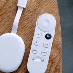 An overhead image of the Chromecast with Google TV HD and its remote on a wooden table.