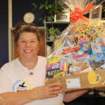 Amanda Baxter holding a packaged box of supplies and smiling