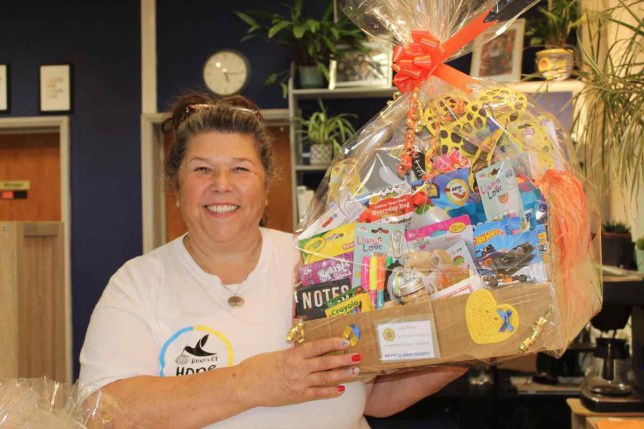 Amanda Baxter holding a packaged box of supplies and smiling