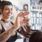 Woman with tattoos cutting woman's hair