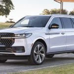 big white SUV in front of a modern building