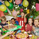 Group children (9-12) at birthday party outdoors