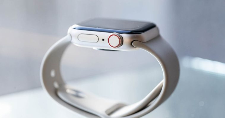 A picture of an Apple Watch SE balanced on its silicone band.