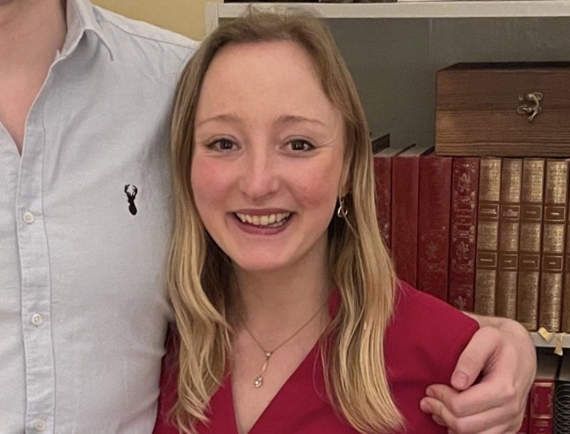 Emily Allen smiling by a bookshelf