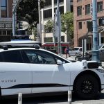 A Waymo car driving on a street.