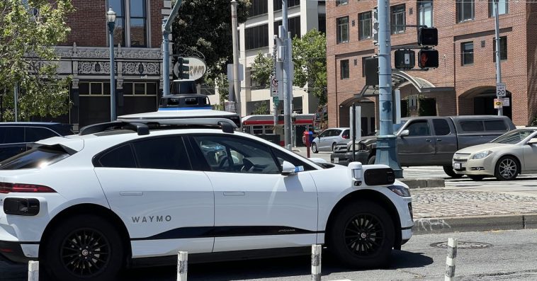 A Waymo car driving on a street.