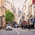 A street in the Latin Quarter of Paris with a Citroen car on the road and thePantheon in view.