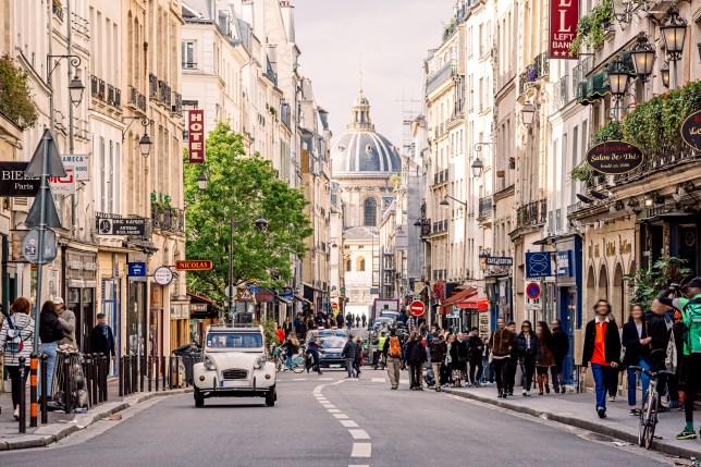 A street in the Latin Quarter of Paris with a Citroen car on the road and thePantheon in view.