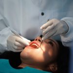 Dentist checking patient's teeth .