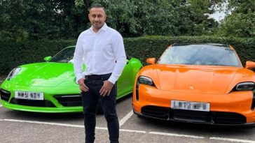 Mindy standing in front of his two Porsche's - green and orange