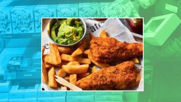 A plate of fish, chips and mushy peas is pictured against a backdrop of M&S supermarket shelves