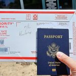 A photo of a person holding a US passport and an envelope.