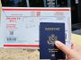 A photo of a person holding a US passport and an envelope.