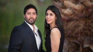 Sheena posing with her husband - both are wearing black