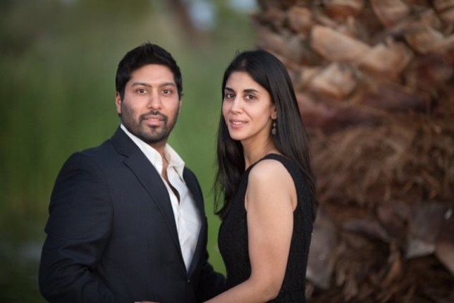 Sheena posing with her husband - both are wearing black