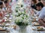 Group of people having dinner at wedding reception table at back yard.