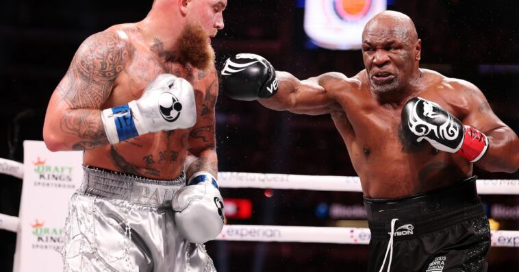 Image showing Mike Tyson, mid-punch as Jake Paul dodges.