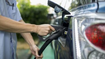 An employee charges a BYD electric vehicle at a charging station in Shenzhen, China