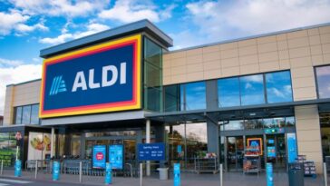 The frontage and brand logo of a branch of German discount retailer Aldi, taken in a local retail park on Wirral, UK on a sunny afternoon