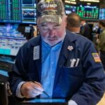 A trader wearing a Trump hat works on the floor of the New York Stock Exchange