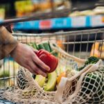 Grocery shopping with reusable shopping bag at supermarket.